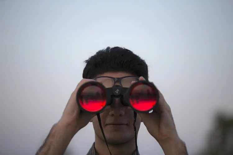 hombre de binoculares rojos