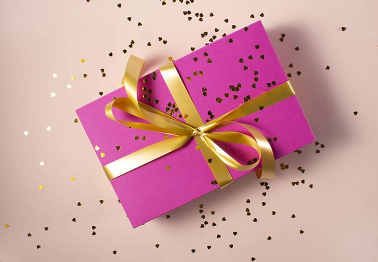 caja de regalo rosa con cinta amarilla