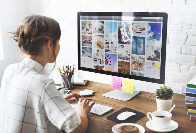최고의 사진 관리 소프트웨어 Best photo management software: Girl sitting on desk organizing photos on a Mac computer