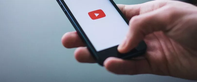 logo youtube sur un smartphone tenu par une personne